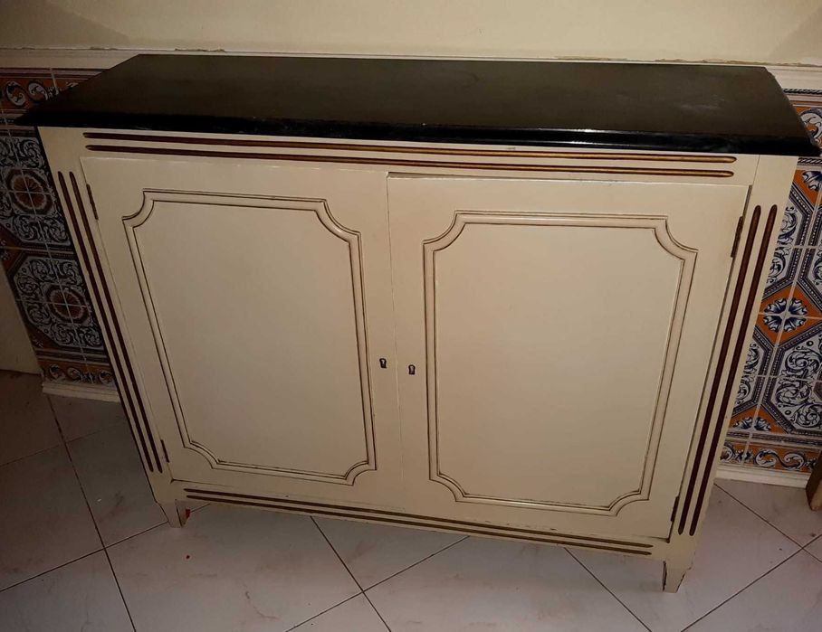 Armário/Consola vintage em madeira maciça com adornos esculpidos em relevo. Com 4 prateleiras e 2 portas de abertura fácil. Tampo em pedra mármore.