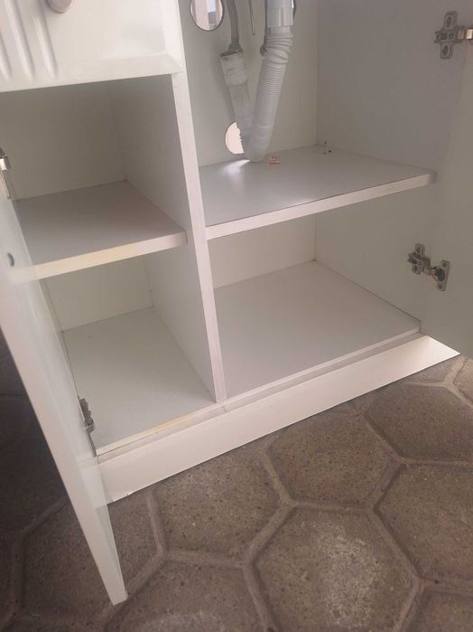 Móvel de casa de banho usado com lavatório em cerâmica e torneira.
