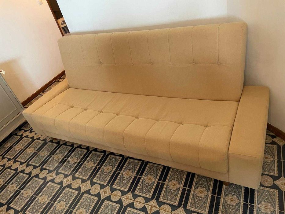 Sofá-cama bege em bom estado.