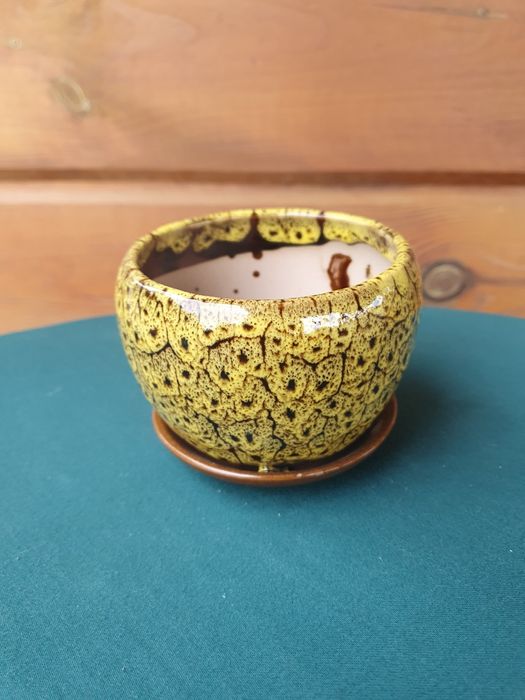 Żółta doniczka ceramiczna z przytwierdzoną podstawką