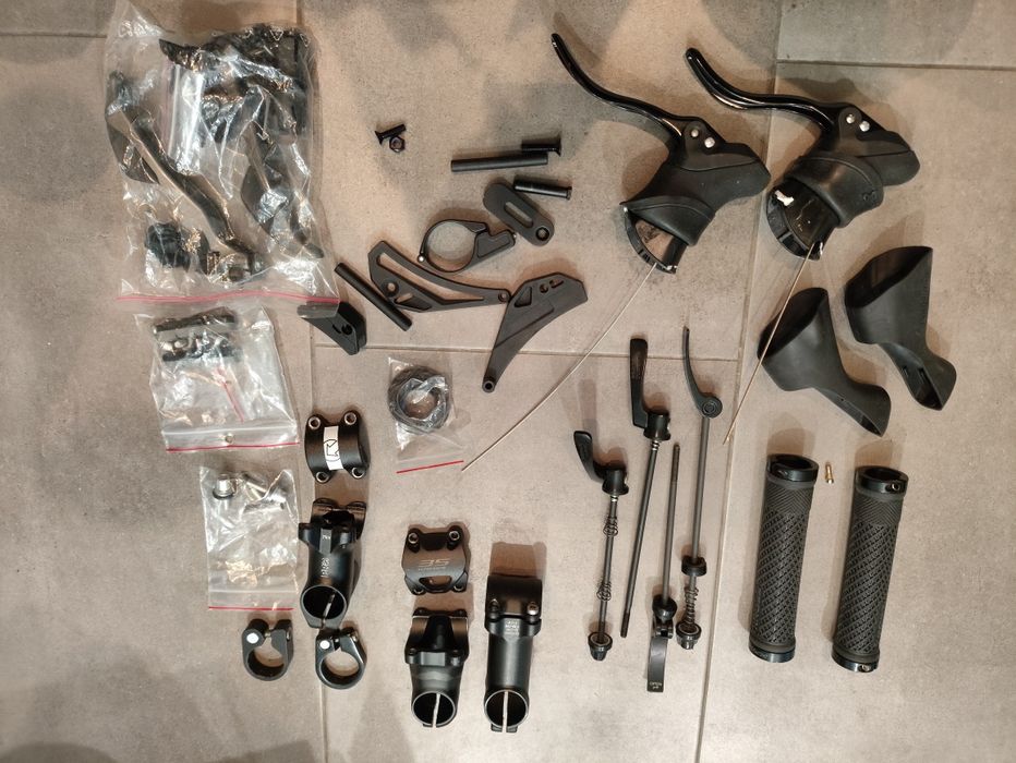 Zbiór części rowerowych: sztyce, hamulce, pedały, akcesoria