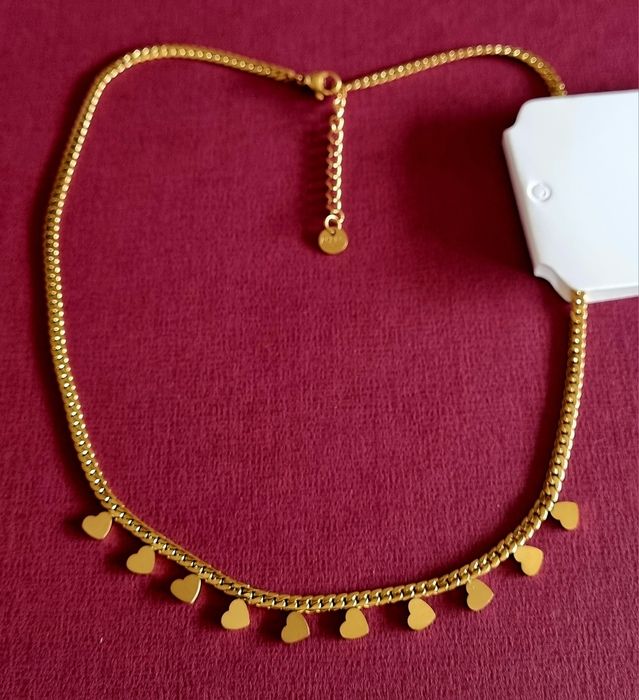 Golden necklace/choker made of steel, with 10 small heart-shaped pendants. Includes an extender.