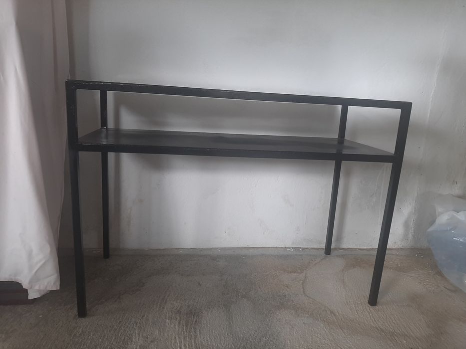 Consola em metal com uma prateleira.