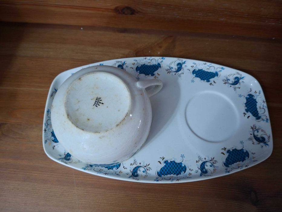 Prato fundo branco com flores azuis e chávena