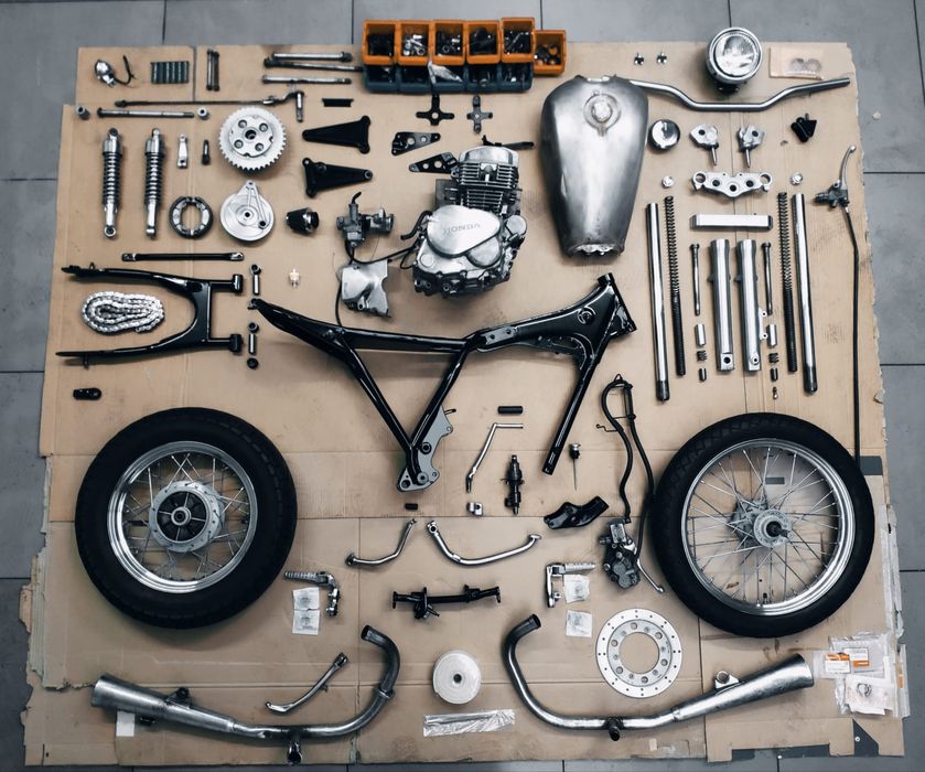 Dismantled motorcycle engine, wheels and spare parts