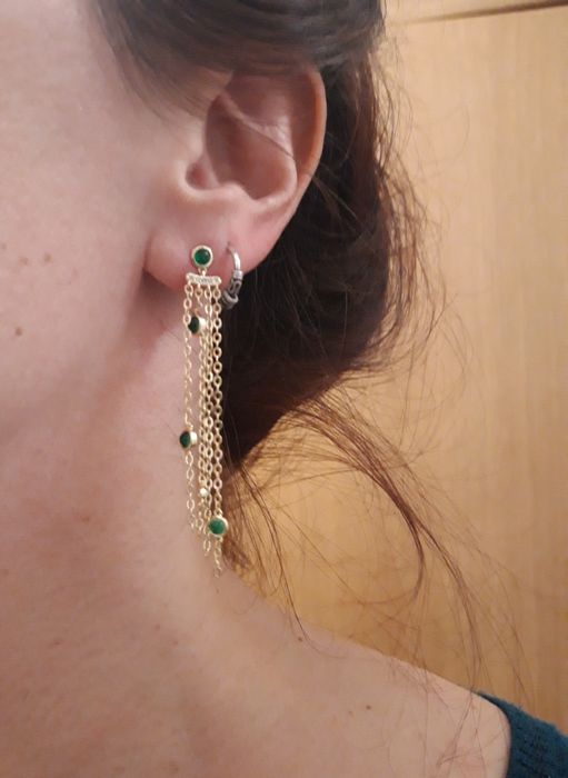 Brincos dourados, assimétricos, com pedrinhas verdes