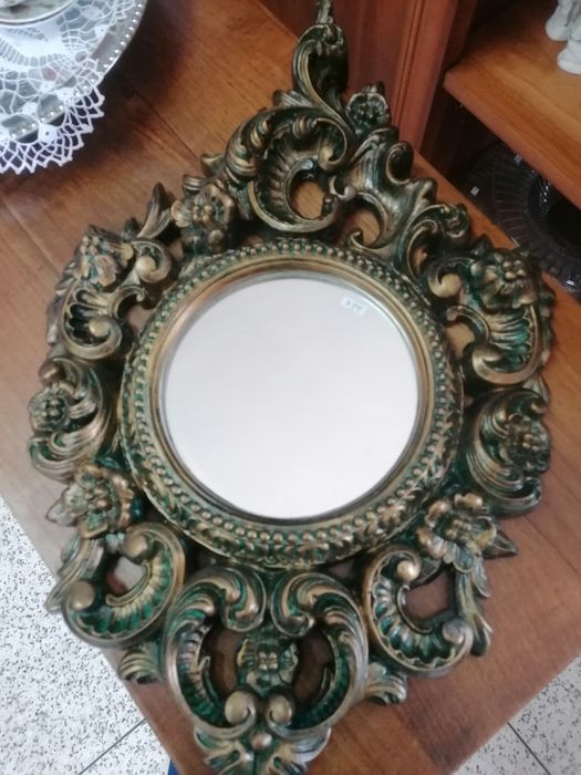 Espelho pequeno, redondo, com moldura ovalizada e em talha