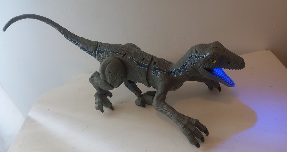 velociraptor dinosaur with sounds and smoke coming out of its mouth.