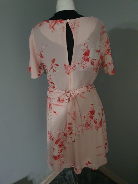 Różowa sukienka w kwiaty wiązana w pasie