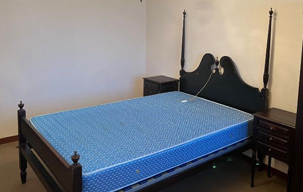 Cama de casal com duas mesas de cabeceira em castanho.