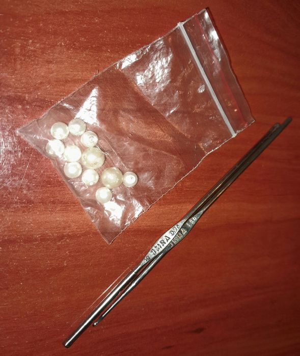 2 agulhas e pequenas pérolas de plástico