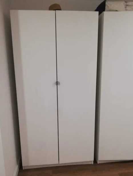 Armário branco com duas portas com prateleiras e varão