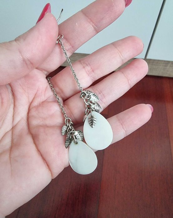 Brincos brancos e prateados com detalhes de folhas