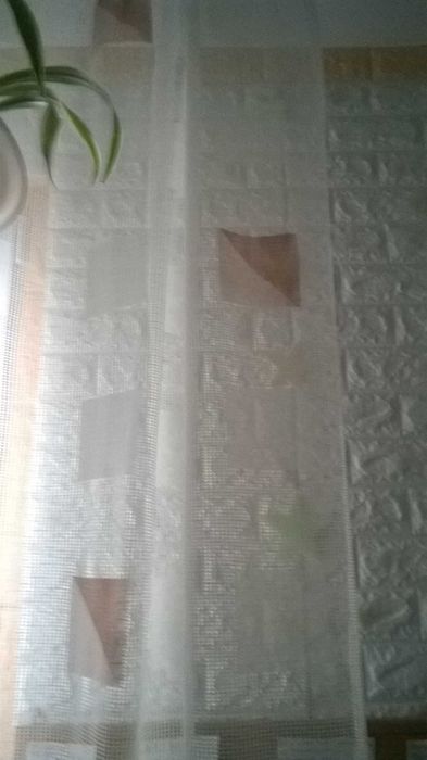 biała firanka z wzorem kwadrato- trójkątów