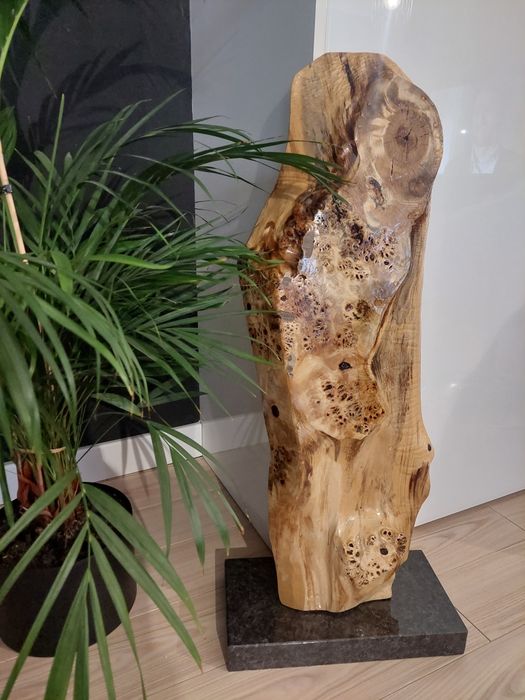 Rzeźba z naturalnego drewna na czarnym granicie