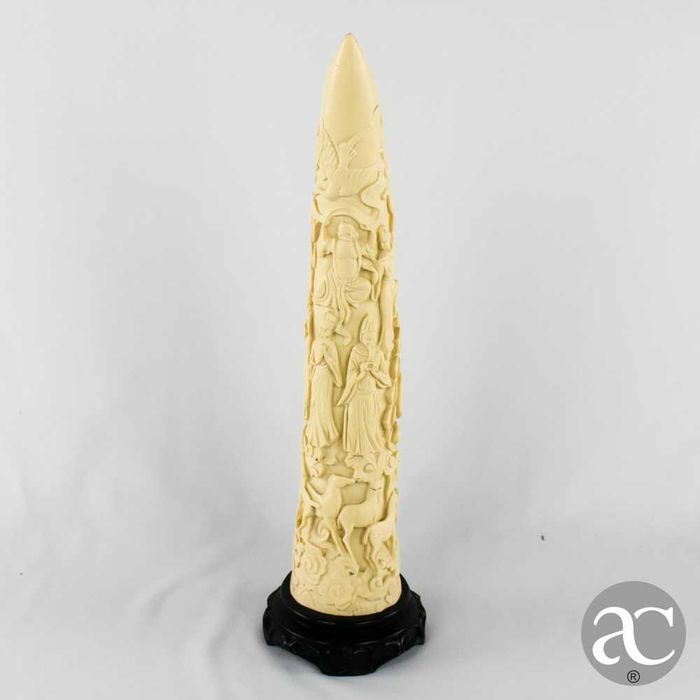 Escultura marfinite forma de dente de elefante com figuras orientais