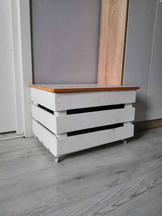 Duża biała skrzynia skrzynka z kołkami na kółkach.