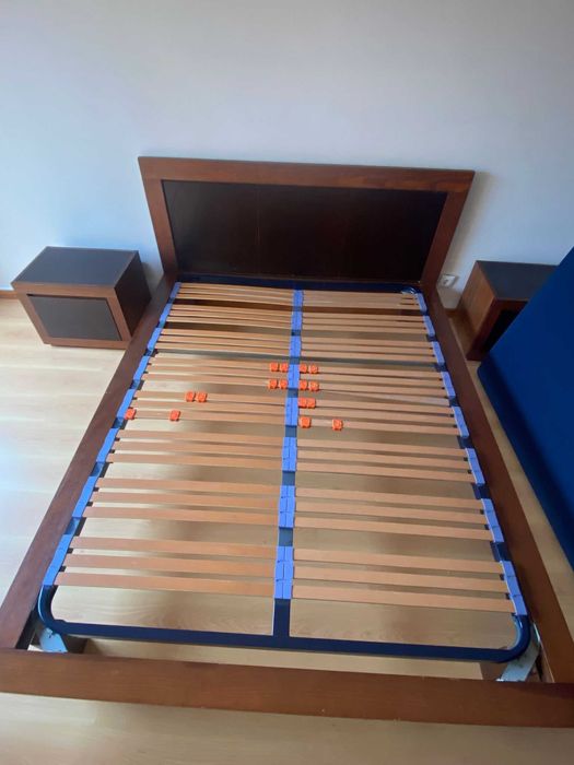 Cama de casal com mesas de cabeceira e estrado