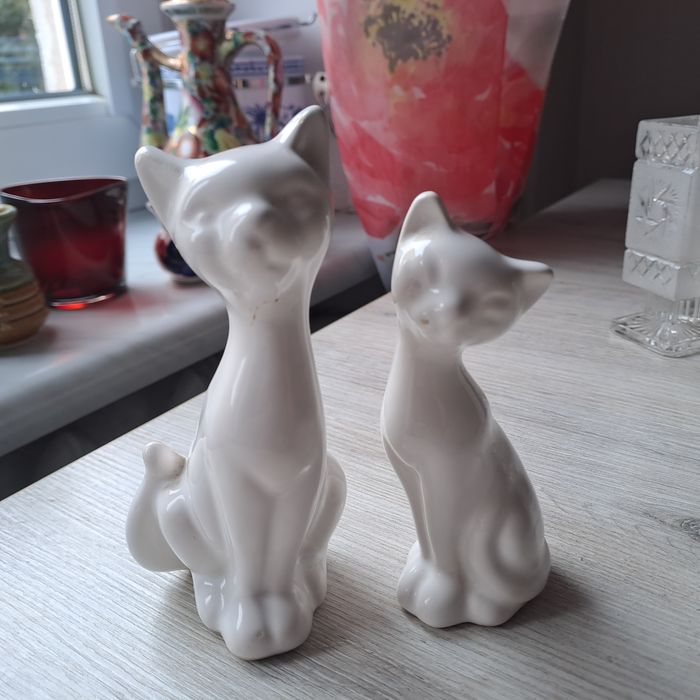 Białe figurki kotki.