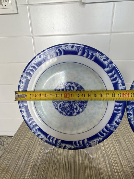 Dois pares de pratos e taças em porcelana azul e branca.