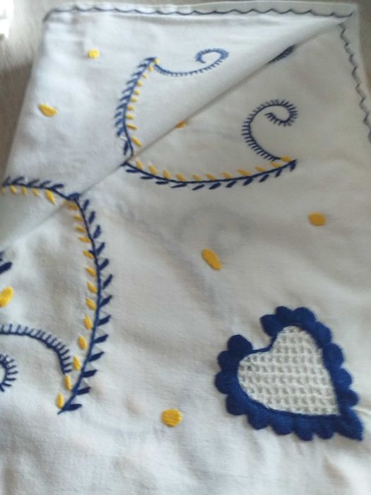 Toalha branca 2x1,50, bordada a azul e amarelo.