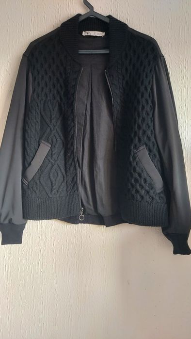 Casaco de malha trabalhada à  frente com bolsos.