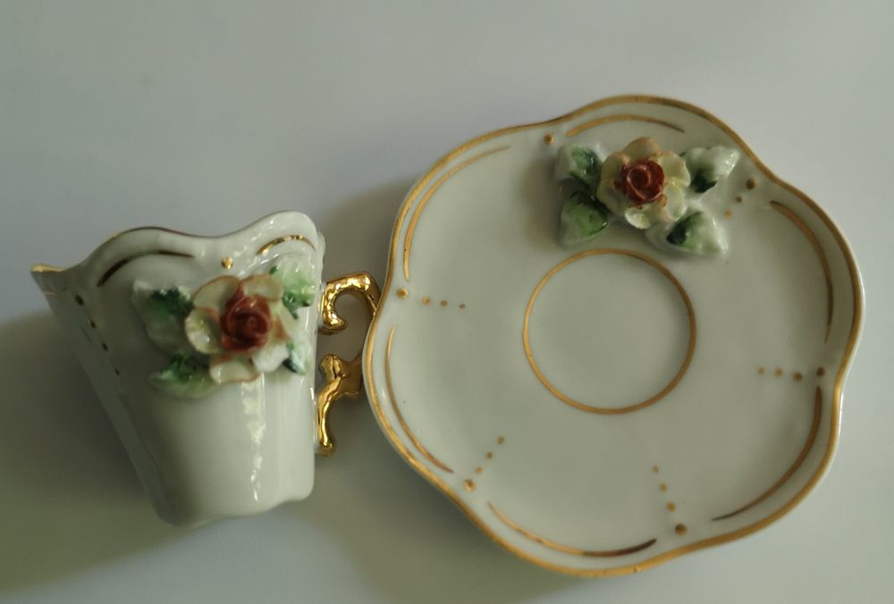 Mini chávena, branca com flores em relevo.