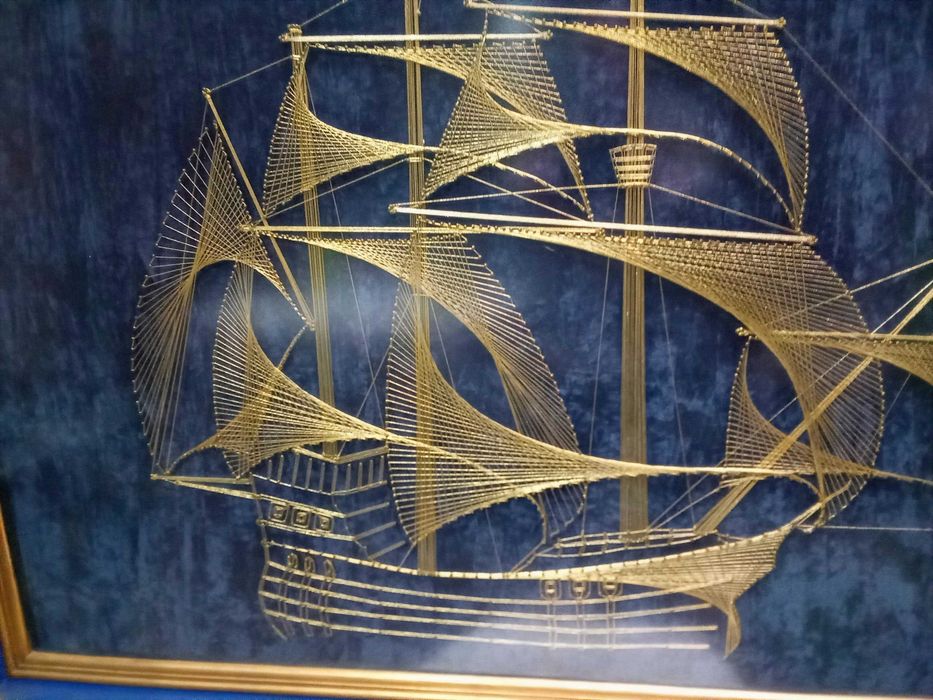 Quadro construído com fio dourado a representar uma caravela Portuguesa
