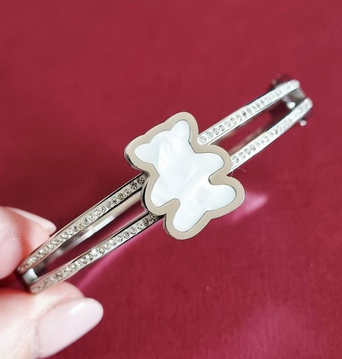 Pulseira/escrava prateada, em aço, com zirconias e um urso em madrepér