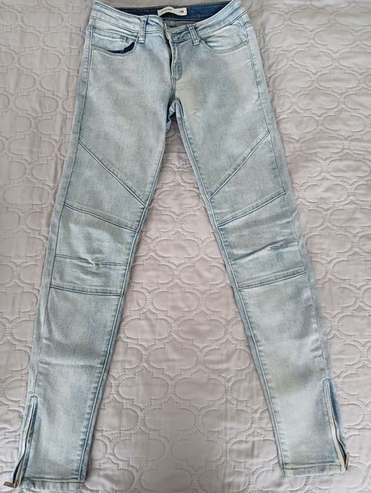 Jasne spodnie z przeszyciami i suwakami przy kostce