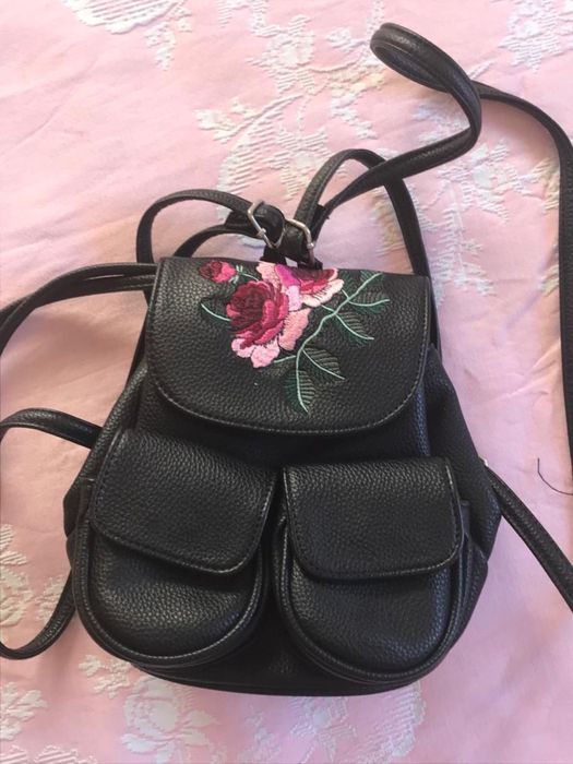 Mochila preta com flor bordada