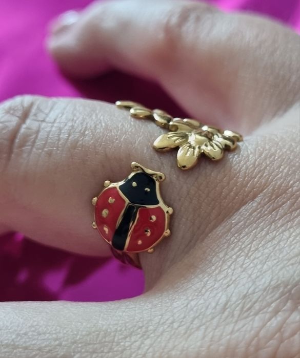 Anel dourado, em aço, com folhas e 1 joaninha. Ajustável