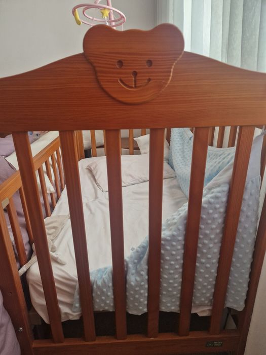 Berço com roupa de cama e mobile.