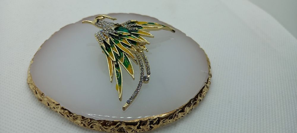 Broszka feniks z zielonym oczkiem.