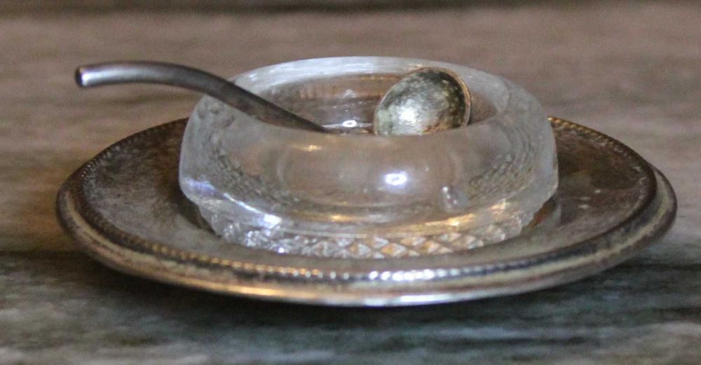 Saleiro de cristal com prato e pequena colher em casquinha, marcado.