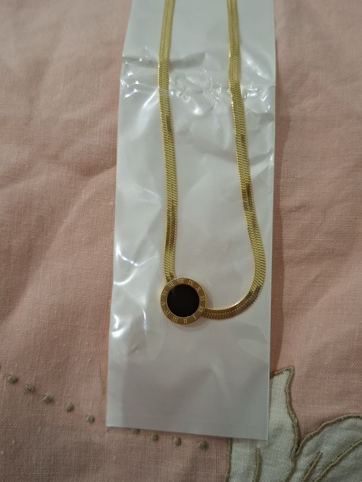 Colar com pingente dourado e preto em Aço 
Novo