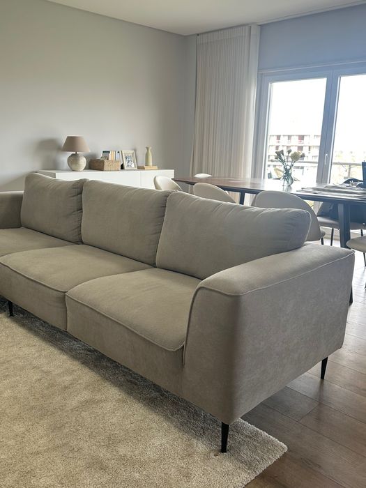 Sofá chaise long cinza com os pés pretos