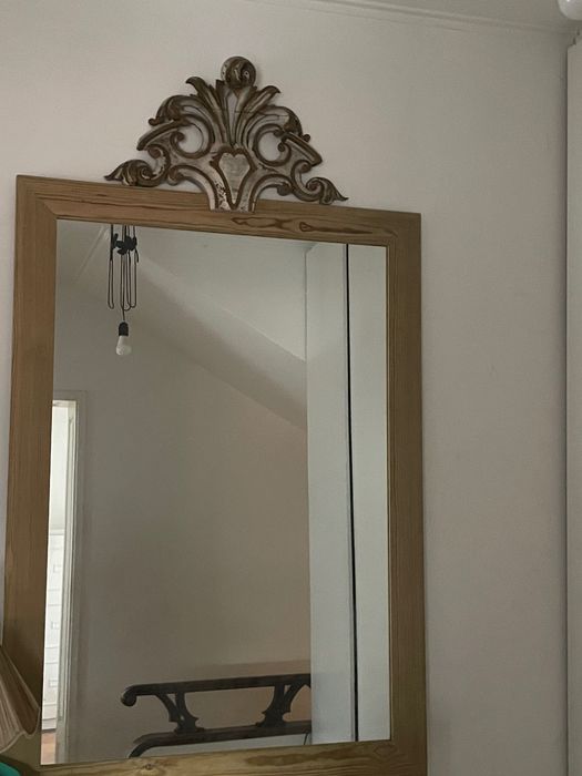 espelho antigo com moldura de madeira e frontão entalhado decorativo.