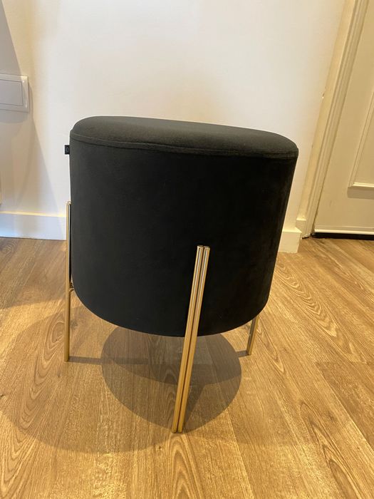 Puff preto com pernas em metal dourado, dimensões 40x34 cm