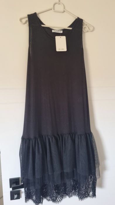 Czarna sukienka bez rękawów z tiulowym dołem i koronką.