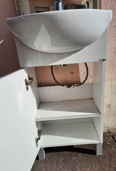 Pequeno móvel com lavatório, torneira e espelho