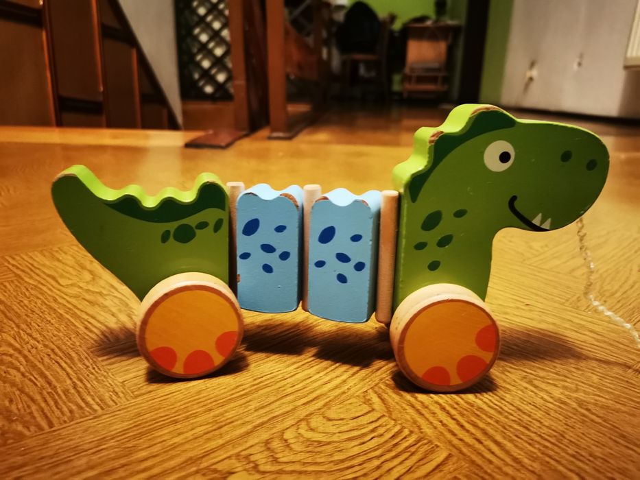 Drewniany dinozaur na sznurku na kółkach