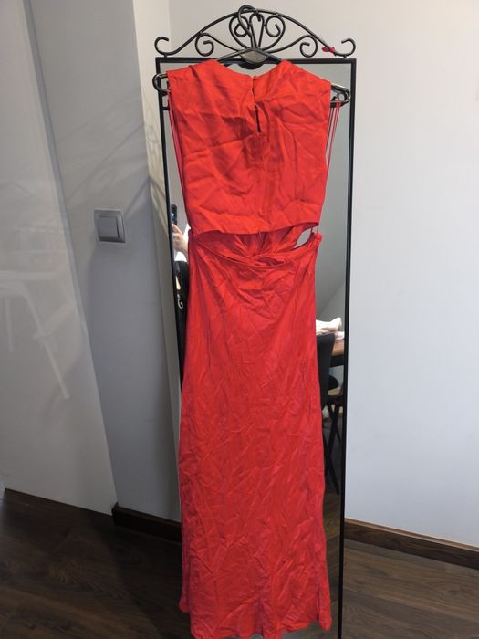 Czerwona sukienka z wyciętymi bokami.