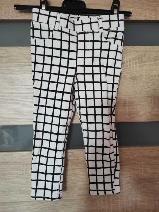Białe spodnie w czarna kratkę dla dziewczynki firmy H&M.