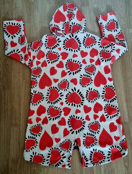 Casaco comprido com corações vermelhos em fundo branco.  TU