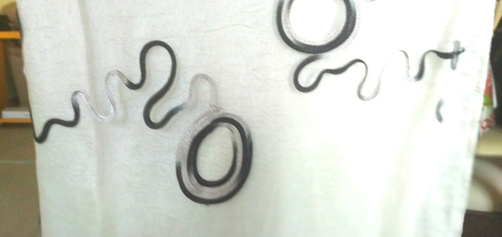 Par de cortinas brancas com apliques pretos e prateados