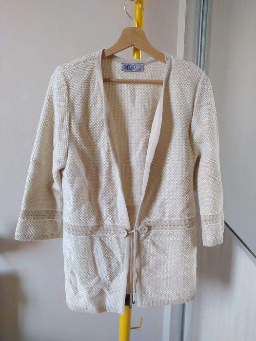 Narzutka, kardigan w beżowym kolorze wiązany z poduszkami na ramionach