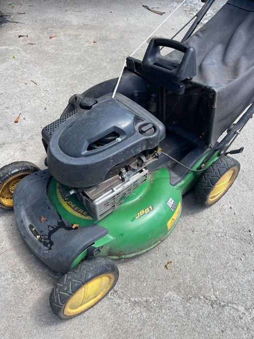 Máquina de cortar relva a gasolina, marca John Deere a funcionar em pleno