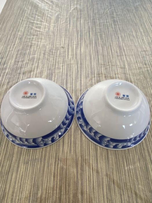 Dois pares de pratos e taças em porcelana azul e branca.