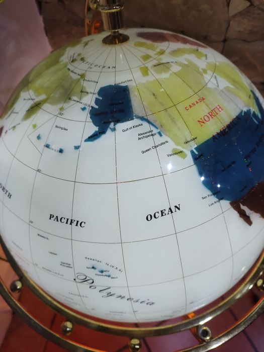 Globo com o mapa do mundo com estrutura em pedra e com base de madeira